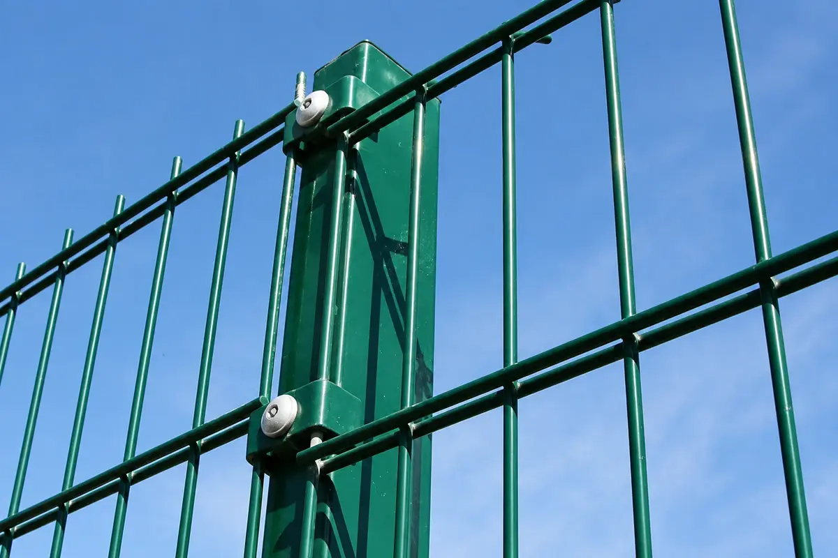 Two clips securing paired horizontal mesh wires to a green post