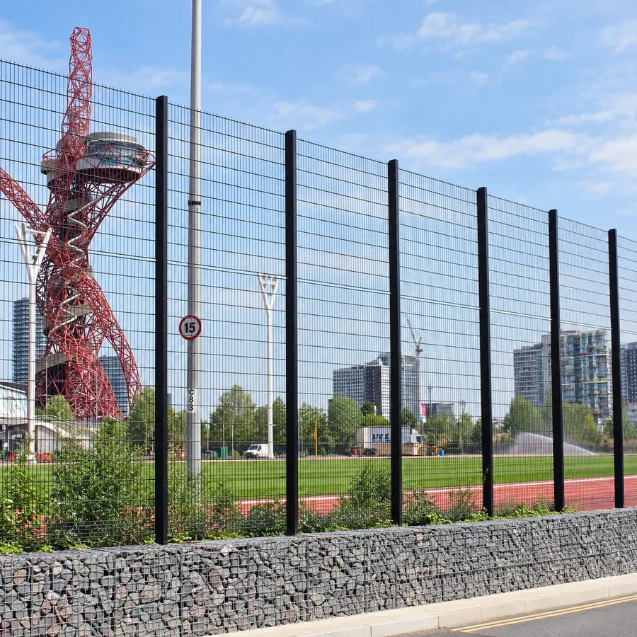 Tall twin-wire fencing beside a running track