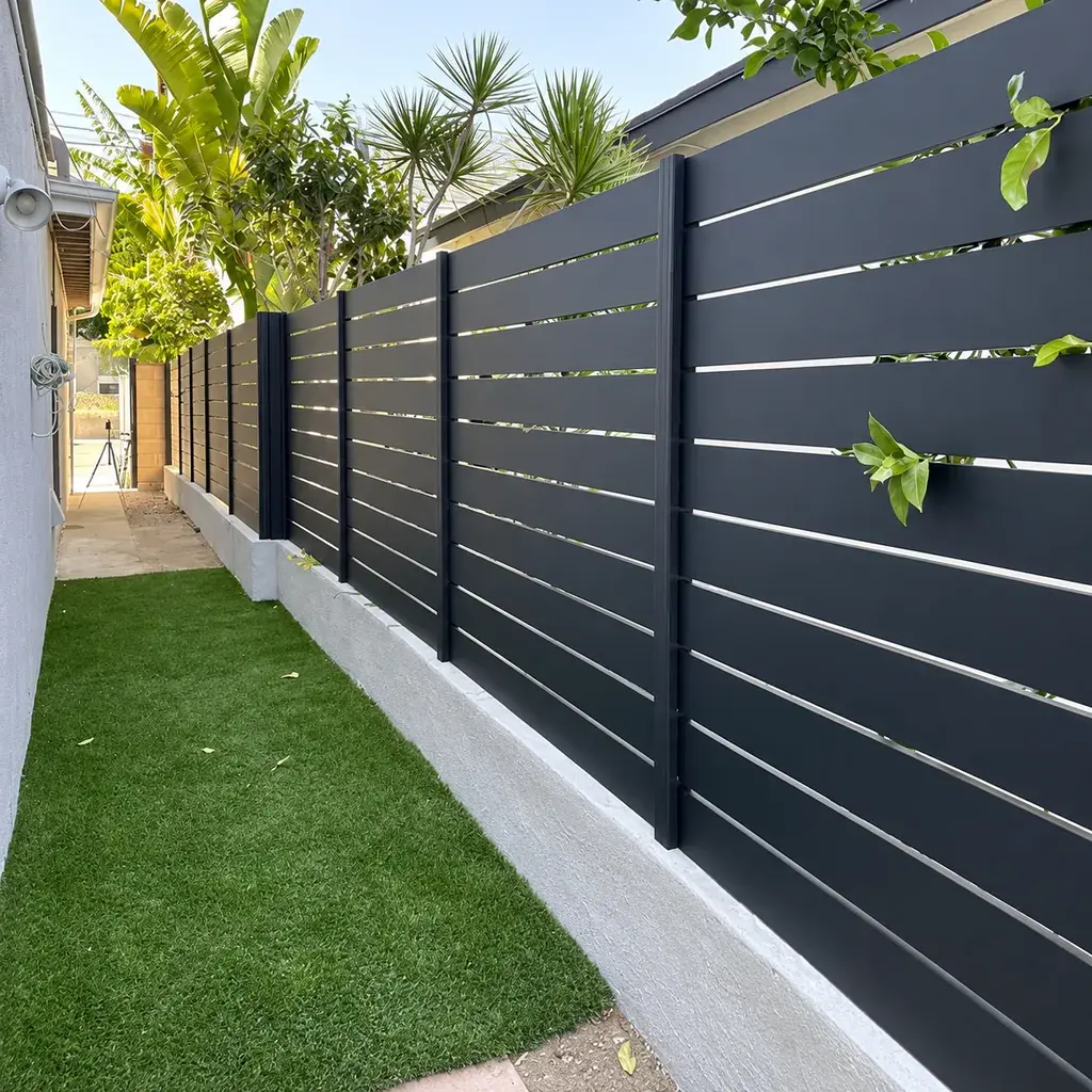 Charcoal horizontal aluminium slat fence beside a residential walkway