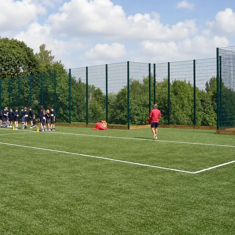 Tall sports boundary behind a football pitch