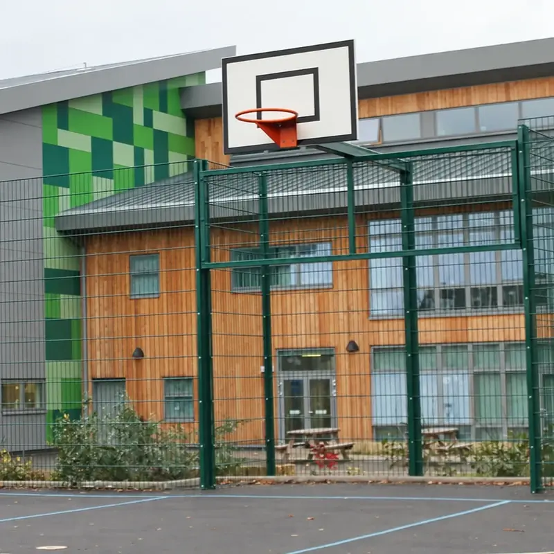 Posts and mesh panels around a school sports court