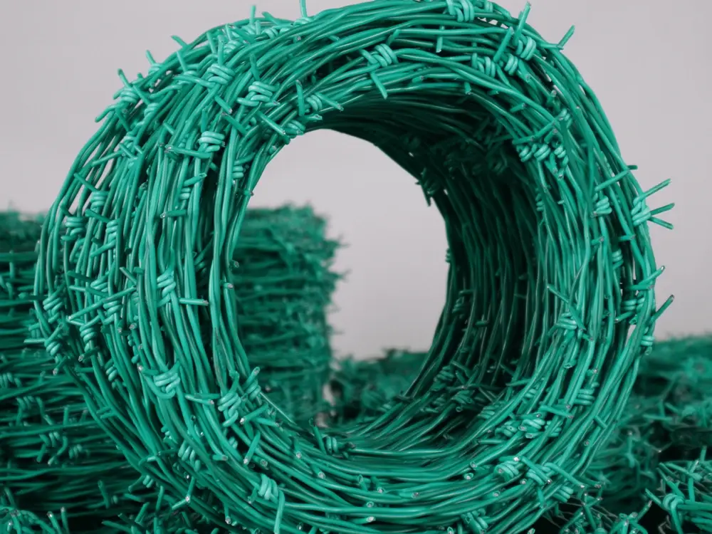 Coil of green PVC-coated barbed wire
