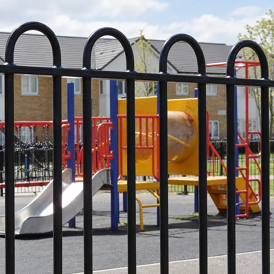 Black bow top railings around a playground