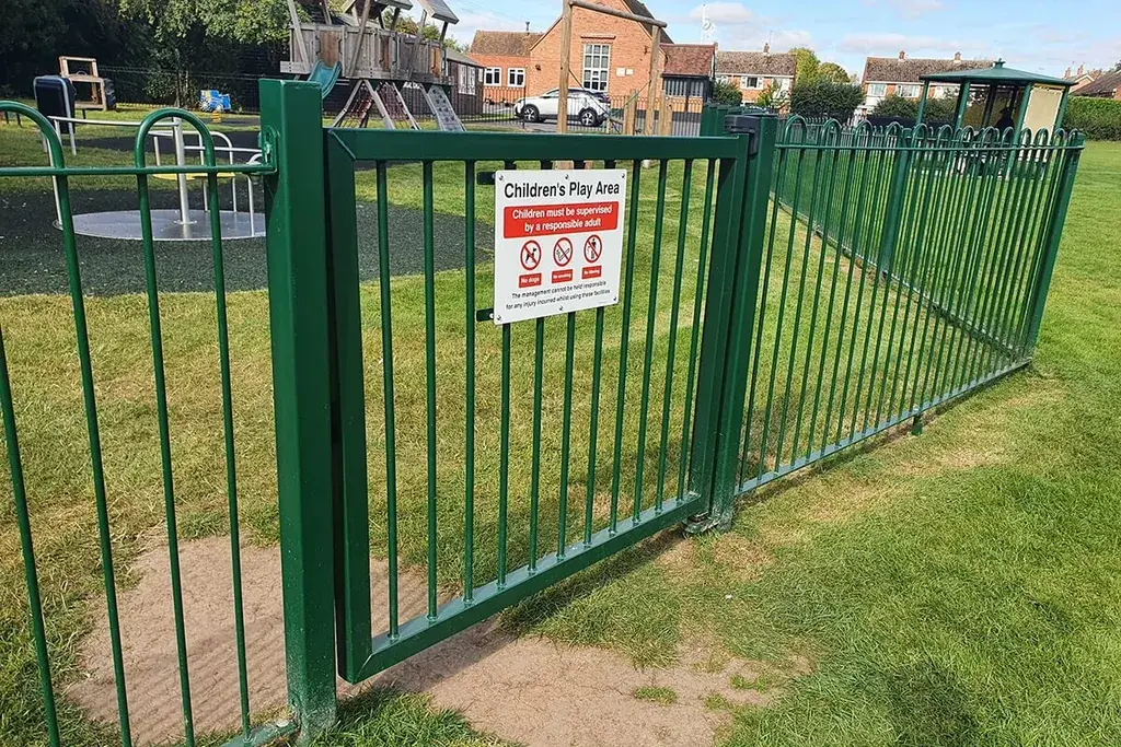 Green bow top gate meeting adjacent railing panels