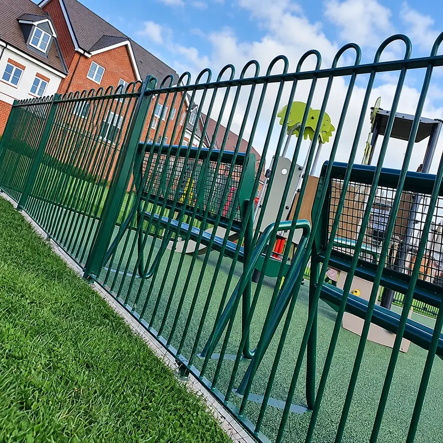 Green bow top steel railing beside a residential play area