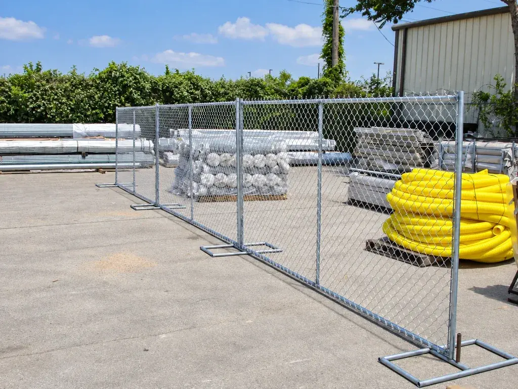 Framed chain link panels standing on metal feet in a storage yard