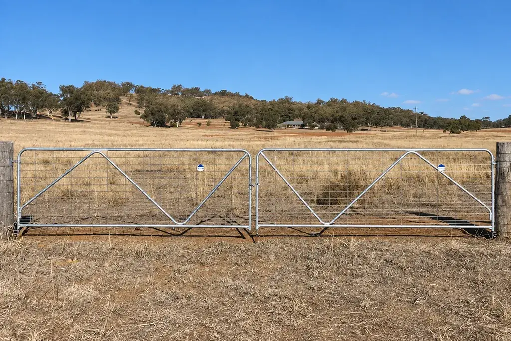 Pair of galvanised mesh farm gates across a field entrance