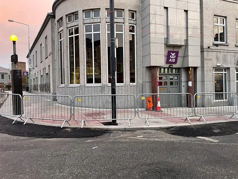 Galvanised crowd barriers guiding pedestrians around a city street