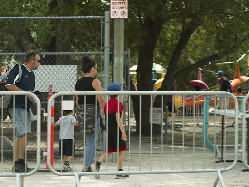 Linked steel crowd barriers separating people from a public walkway