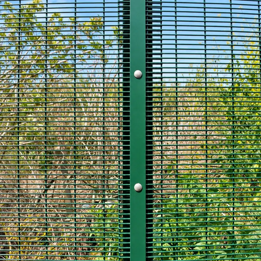 Green close-spaced mesh secured to a post with bolts