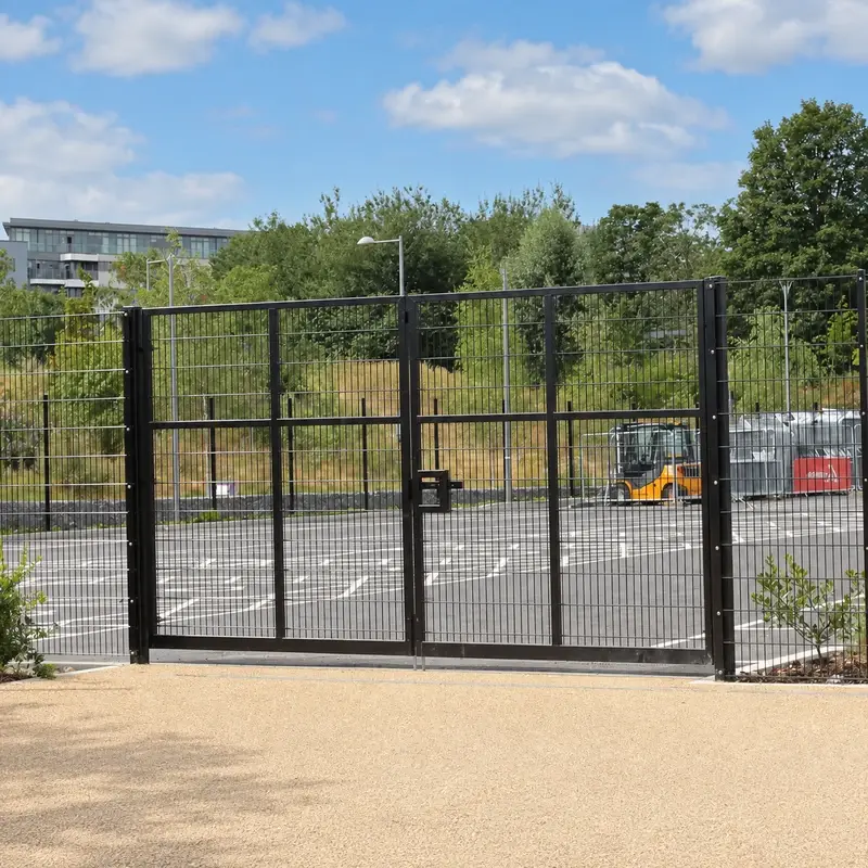 Black double-leaf twin-wire vehicle gate across an entrance