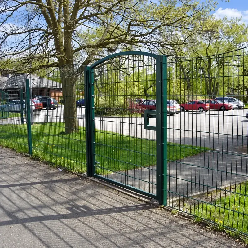 Dark green arched twin-wire pedestrian gate in a fence line