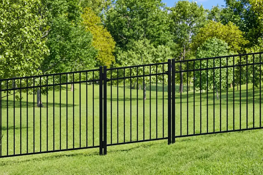 Black metal swing gate within a matching vertical picket fence