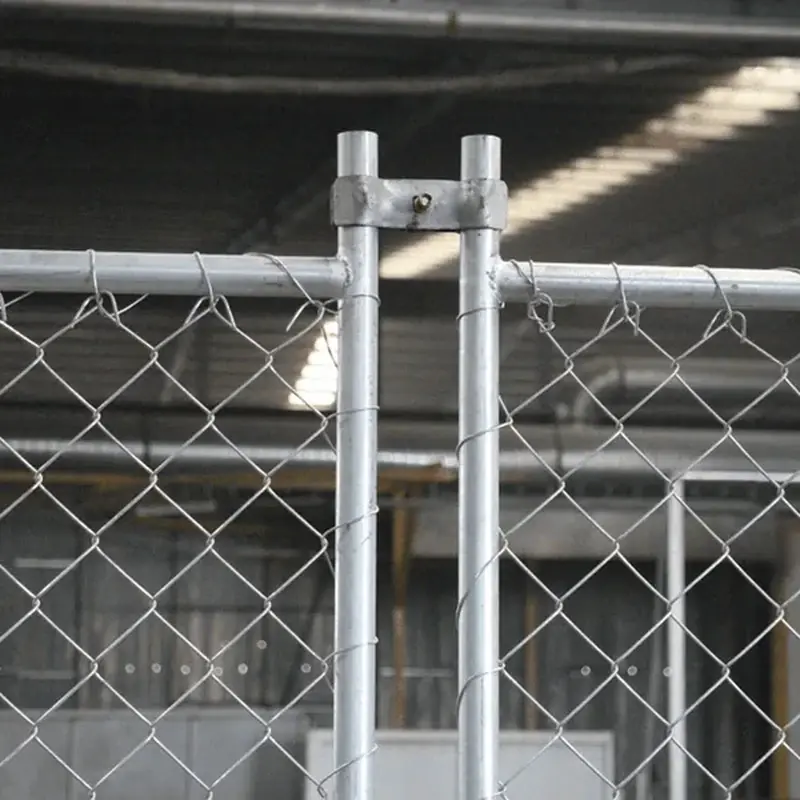 Steel clamp joining chain-link fence components at a post