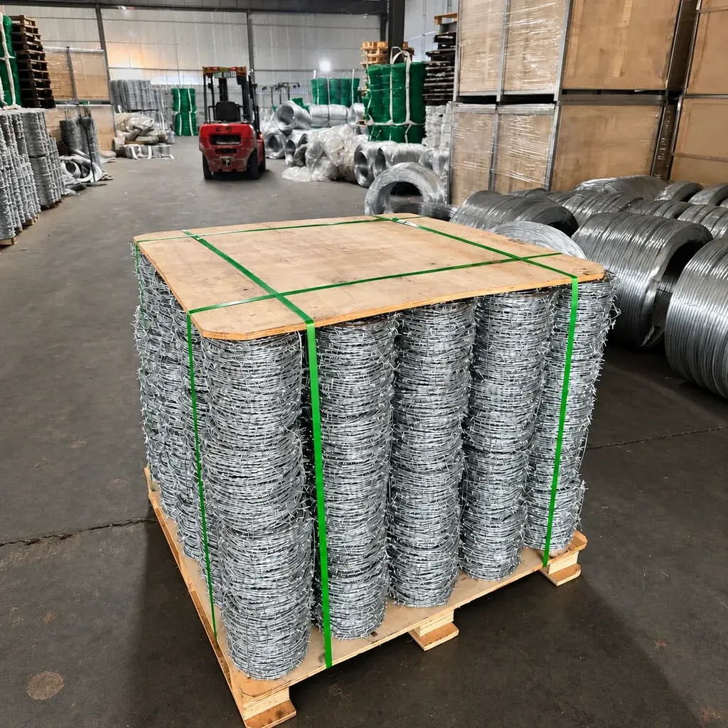Barbed wire rolls strapped on a wooden pallet with a protective top board