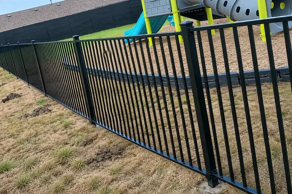 Close view of a flat upper rail and vertical steel pickets