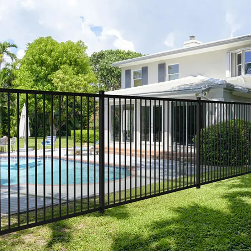 Black flat top steel fence beside a residential garden