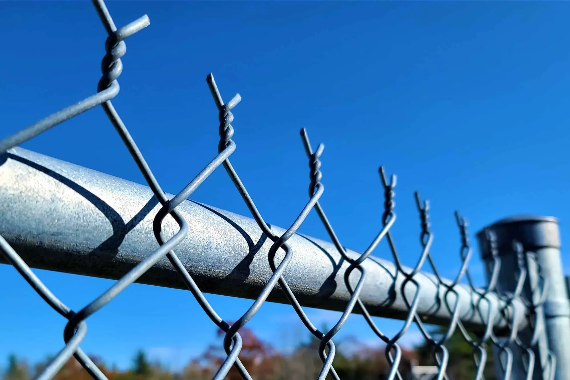 Galvanised chain link wire showing twisted top edge ends