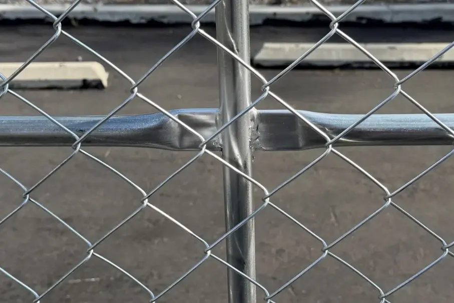 Galvanised chain link fabric meeting a vertical fence post