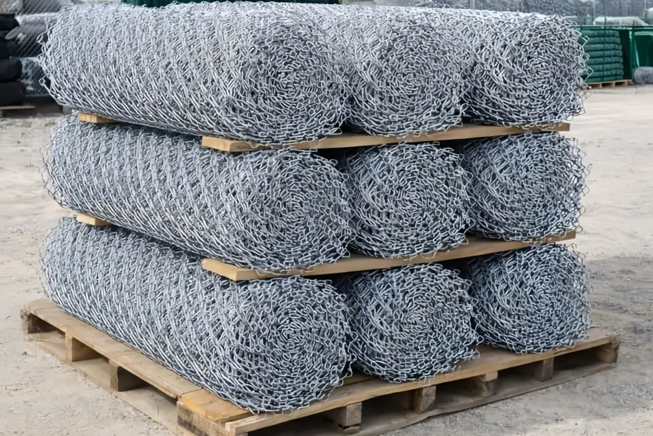 Galvanised chain link fabric rolls stacked on a pallet
