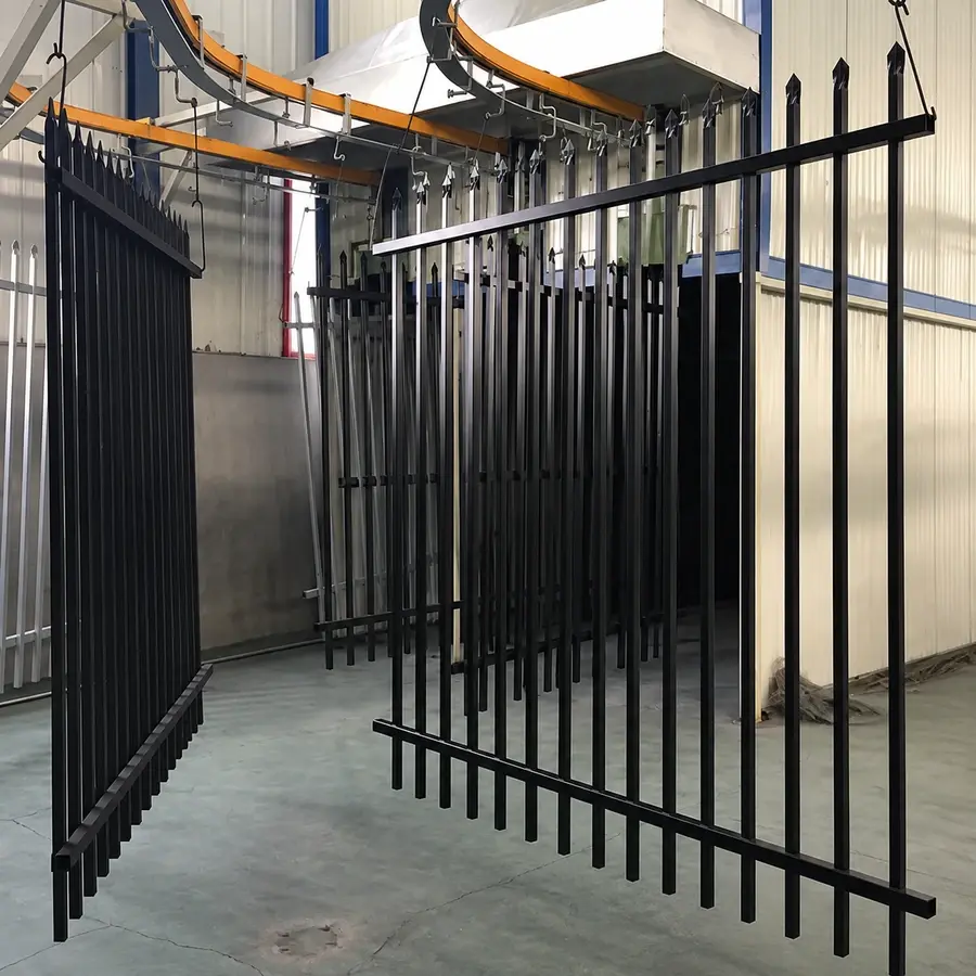 Black spear-top steel panels hanging in a workshop