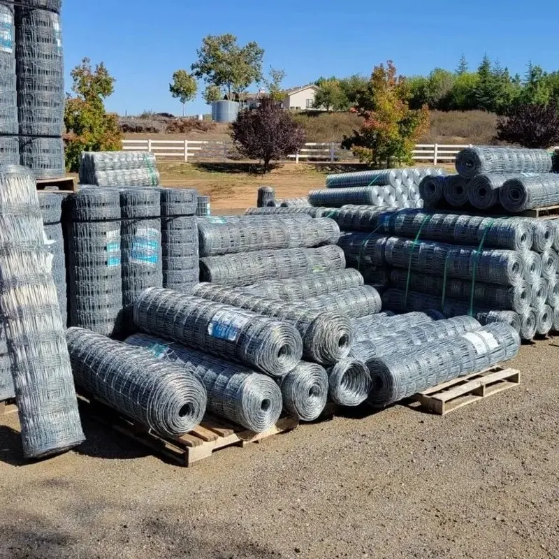 Bulk rolls of hinge-joint field fencing stacked outdoors