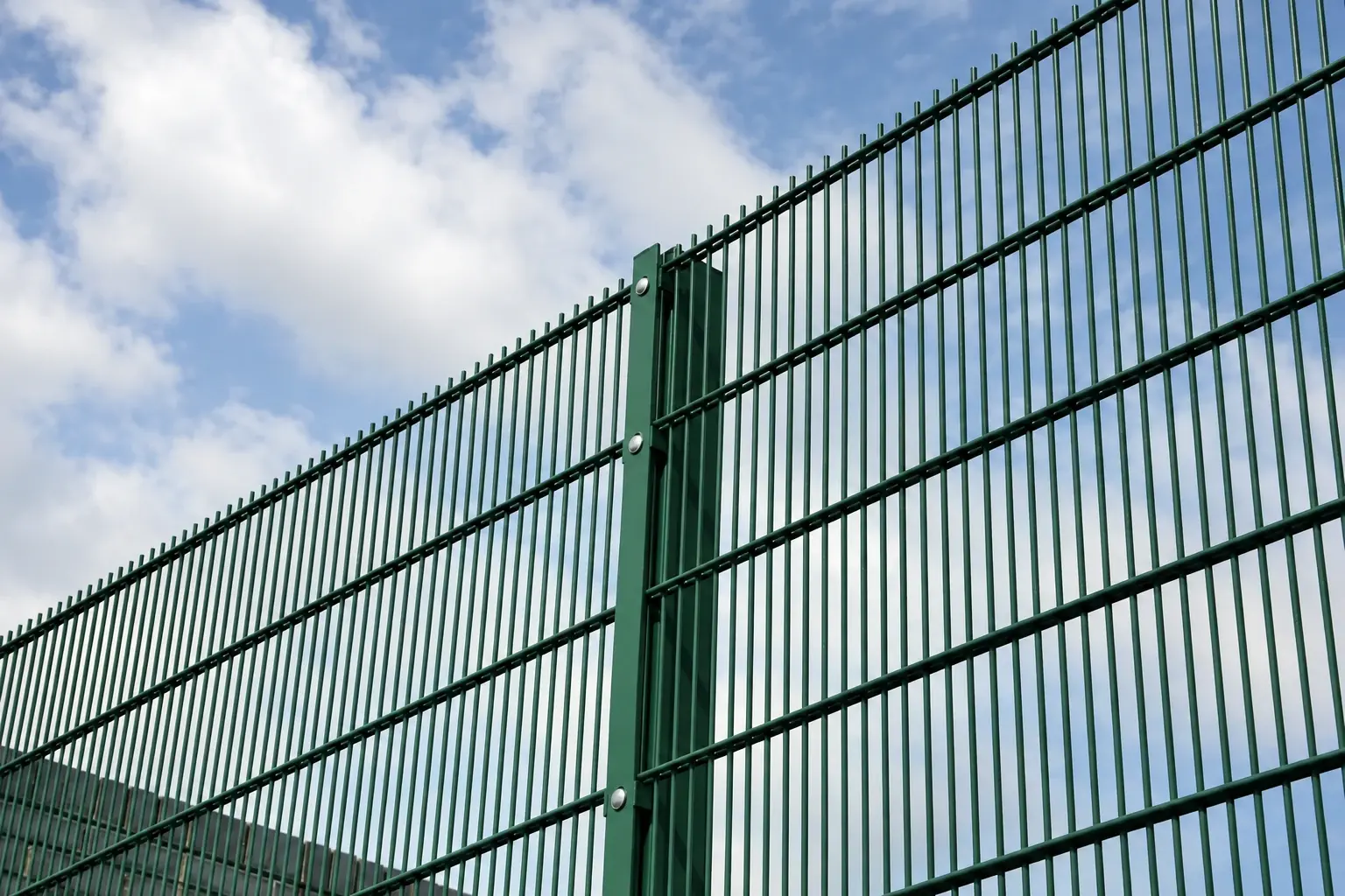 Green double-wire mesh panels and posts viewed from below