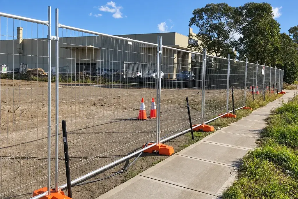 Temporary welded mesh fence panels supported on orange feet