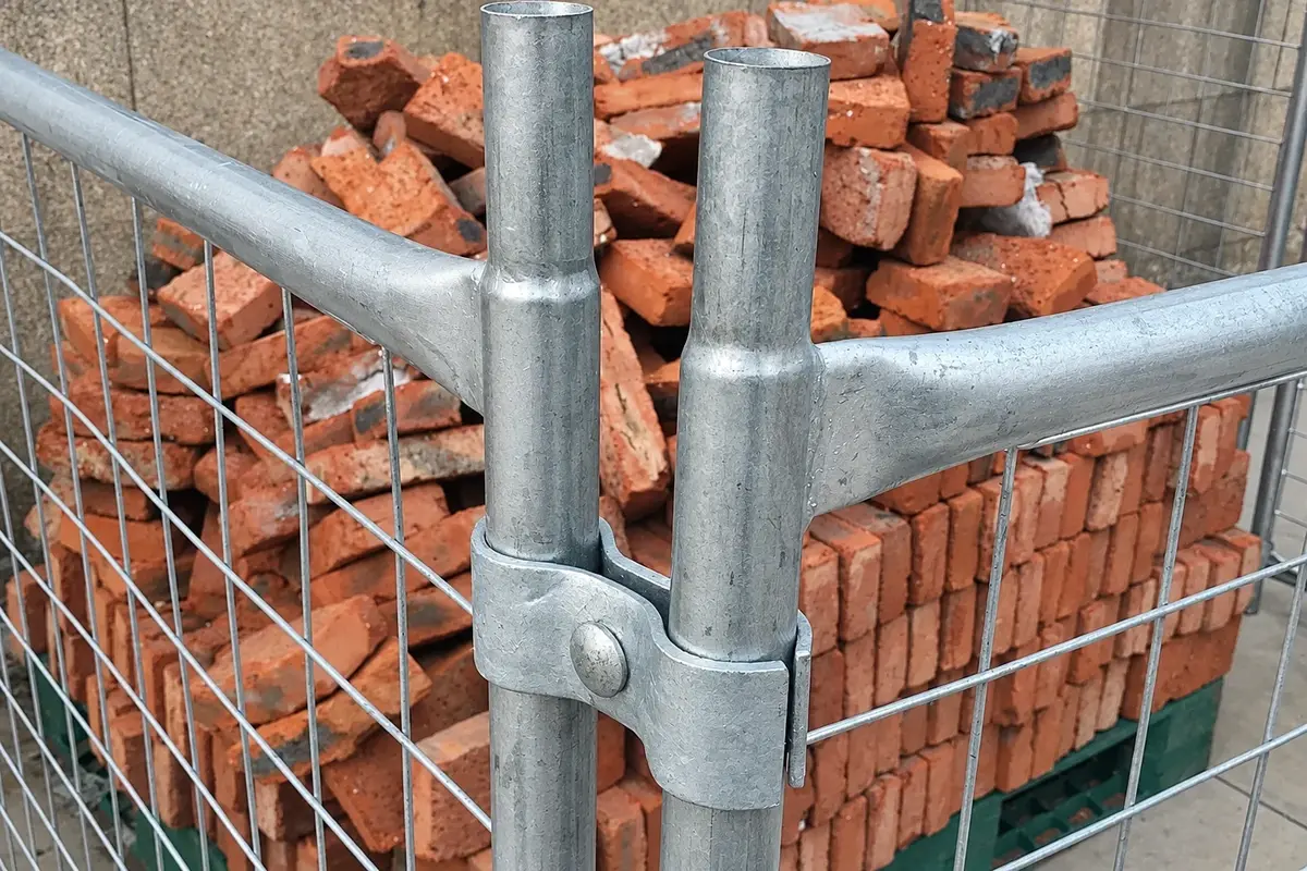 Galvanised mesh fence panels joined at two round steel posts