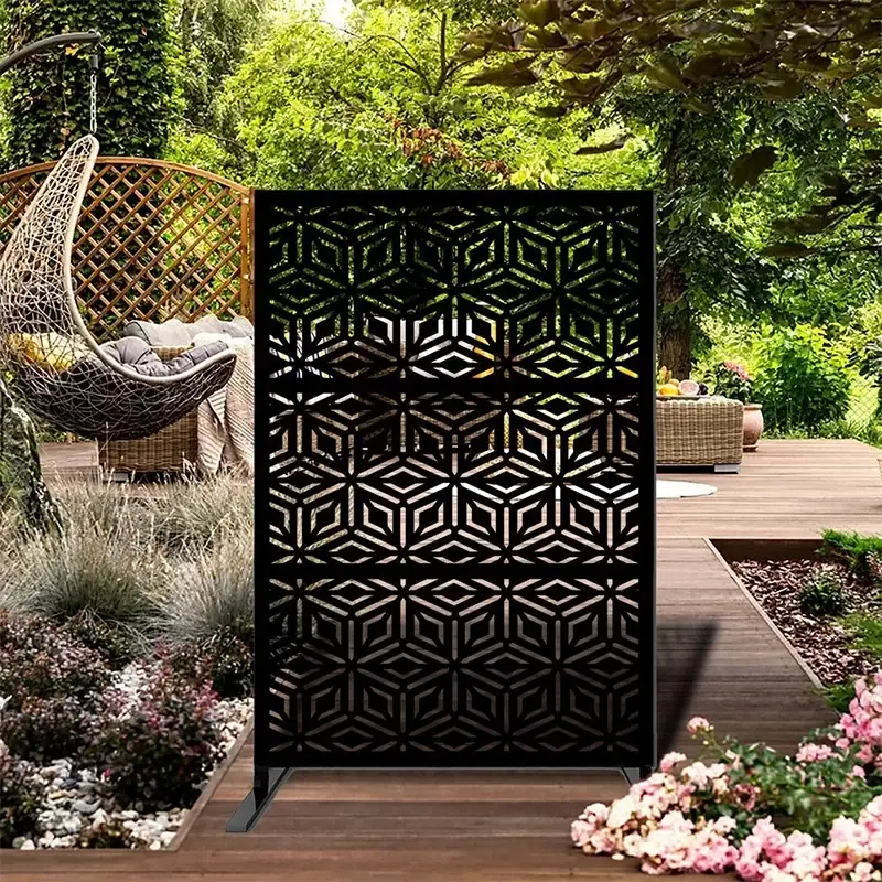 Black patterned metal screen standing in a garden