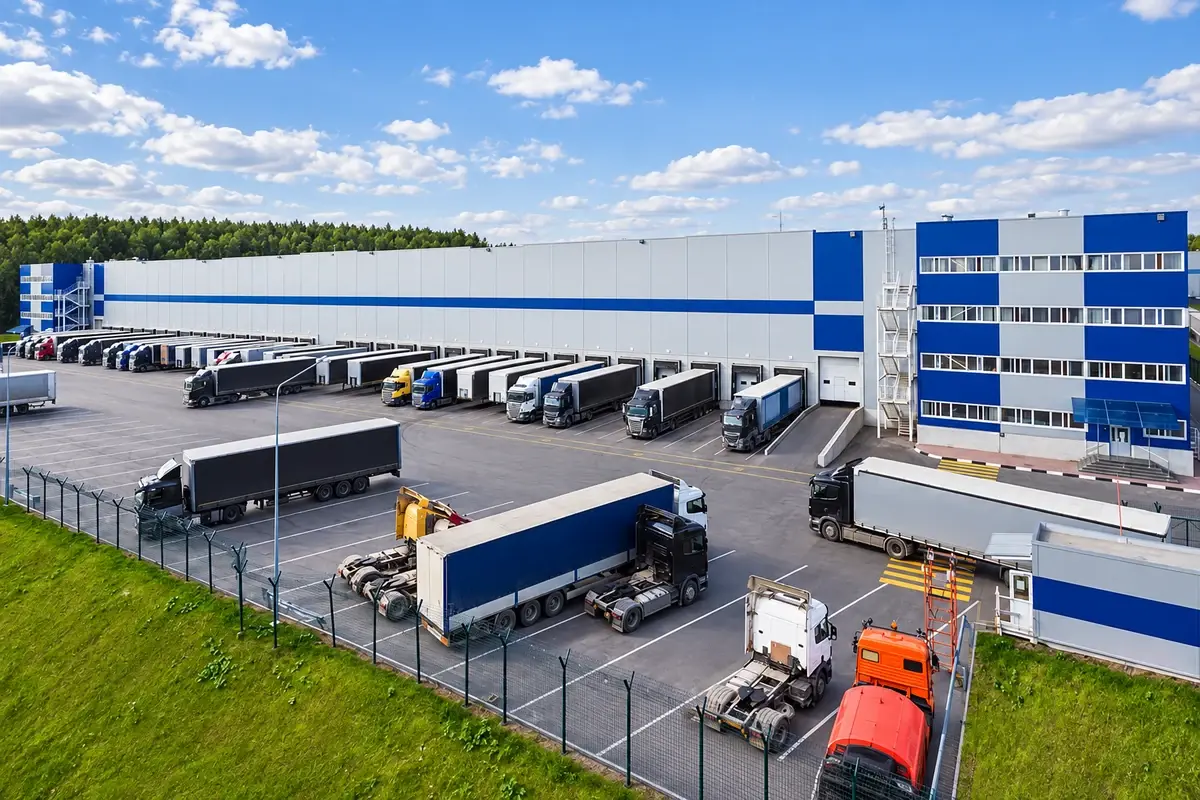 Large logistics building with multiple loading bays and delivery trucks.