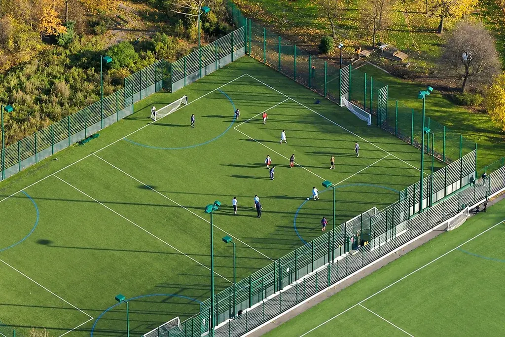 Aerial view of an enclosed multi-use games area with marked courts and goals.