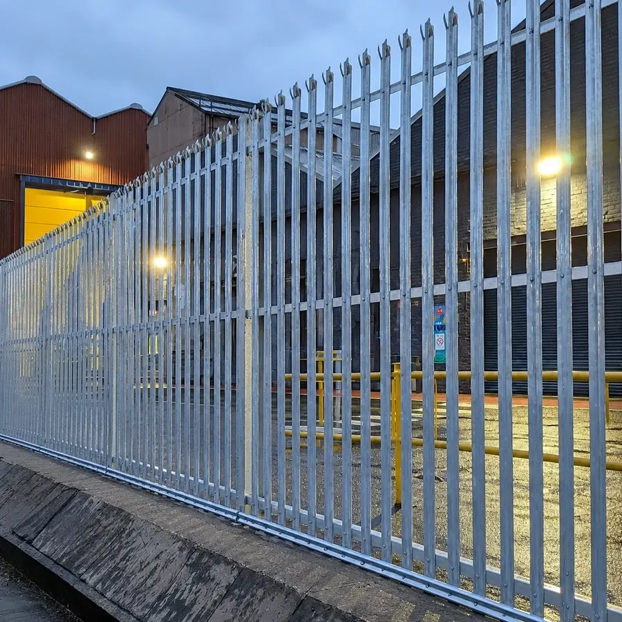 Silver-coloured palisade fencing beside an industrial building