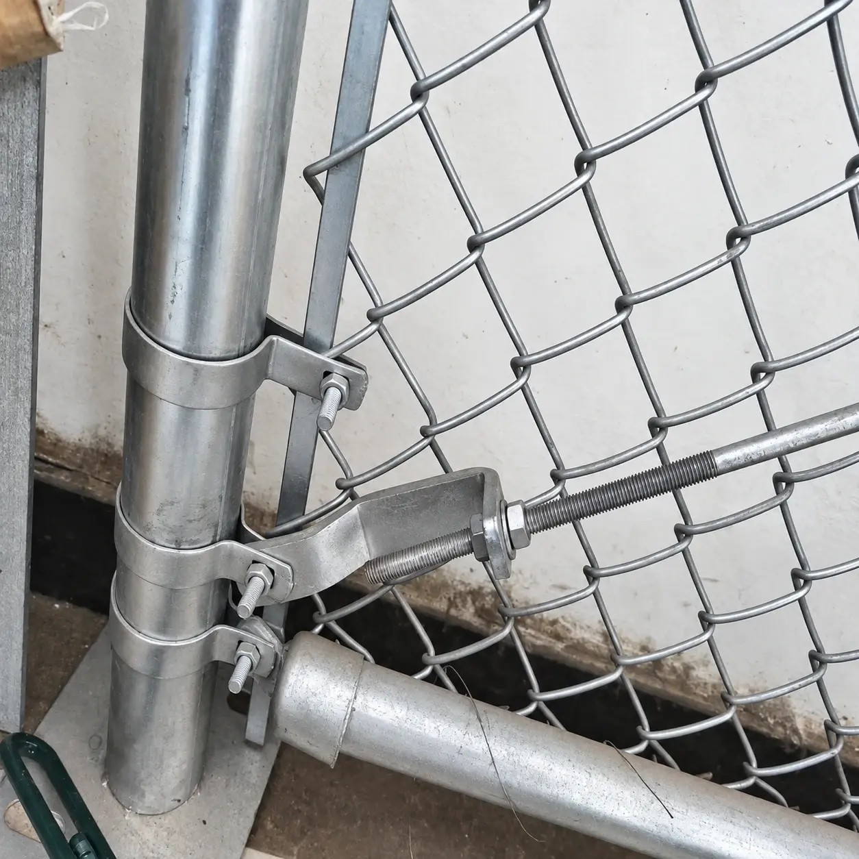 Bolted bands, tension bar and brace connection on a round chain link fence post