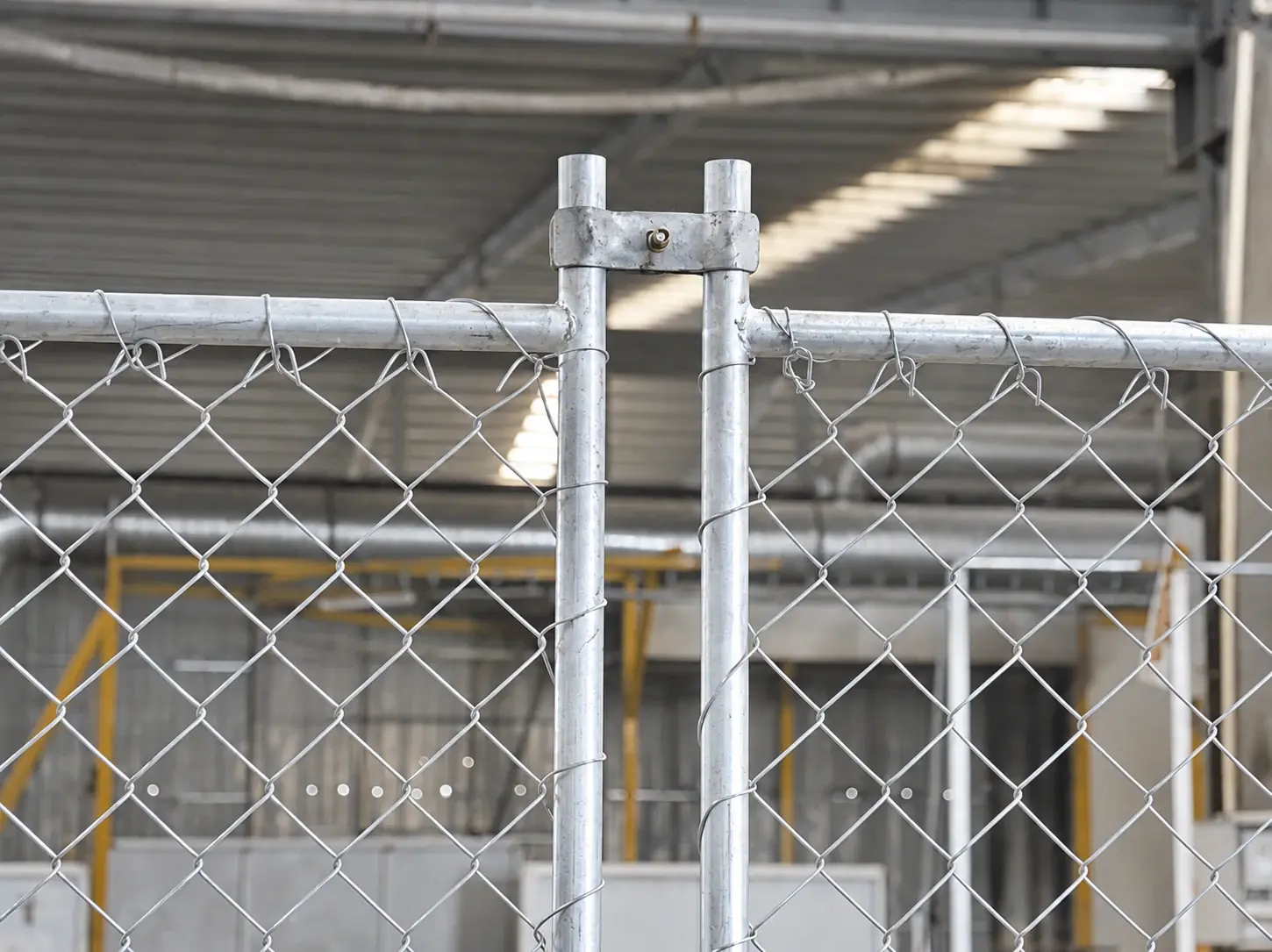 Galvanised clamp joining two tubular chain link fence panel uprights