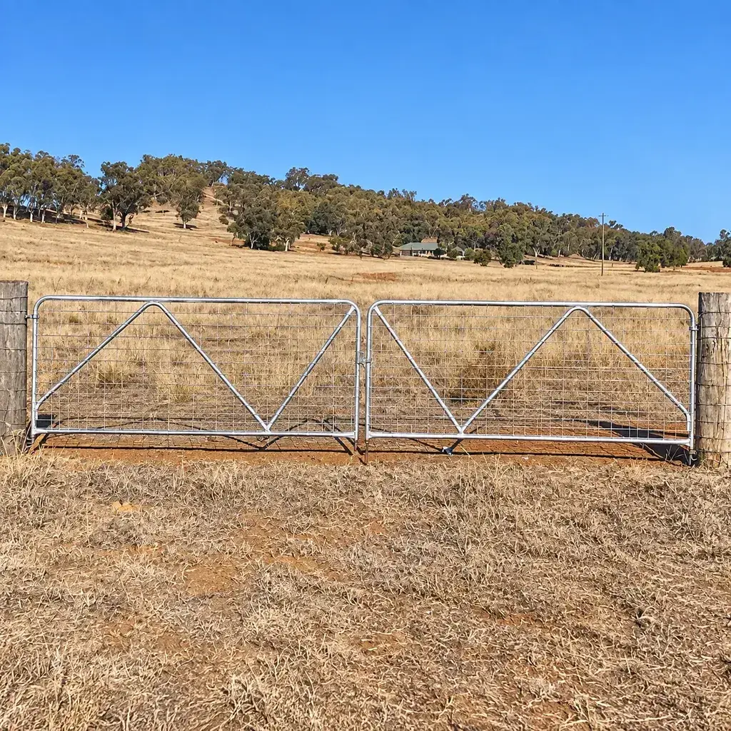 Wire mesh farm gate installed across a field entrance