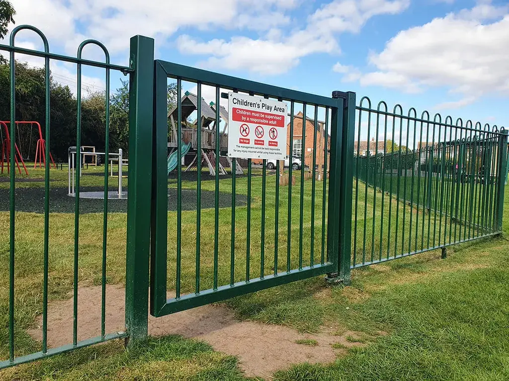 Green bow-top playground gate with a closing mechanism