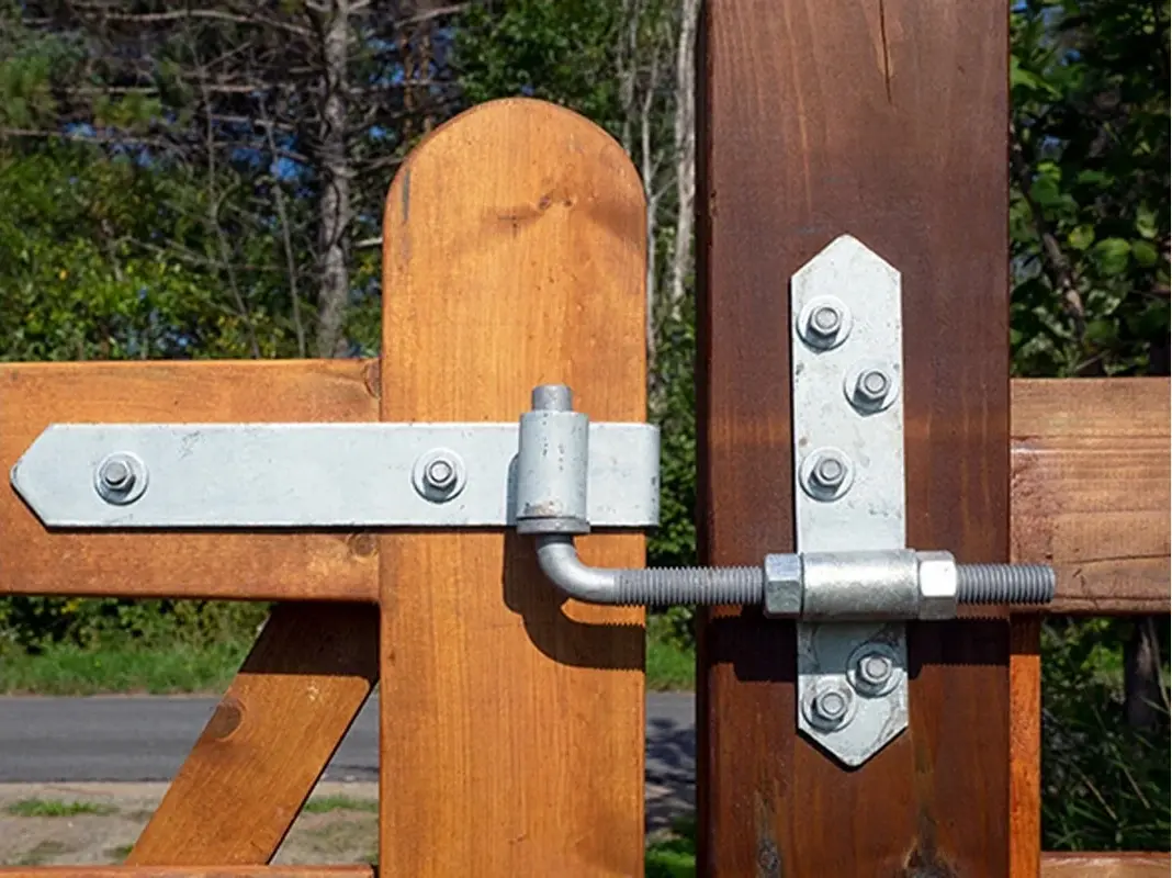 Farm gate hinge attached to a timber support post