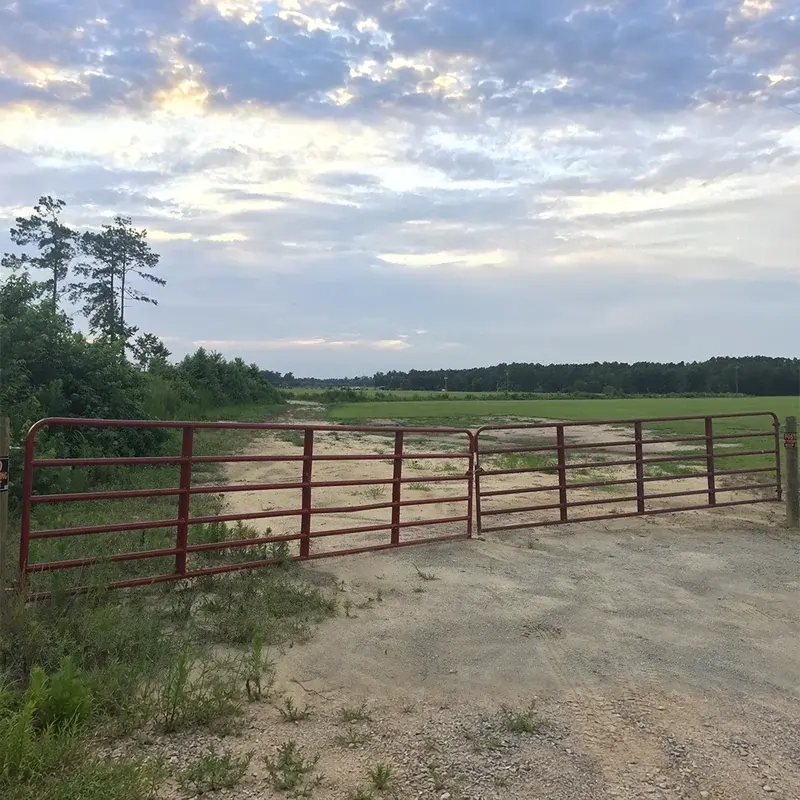 Five-bar farm gate spanning a pasture entrance