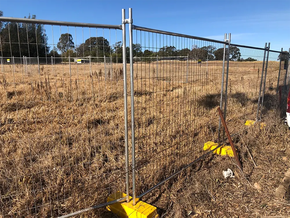 Temporary mesh fence panel braced on a grass site