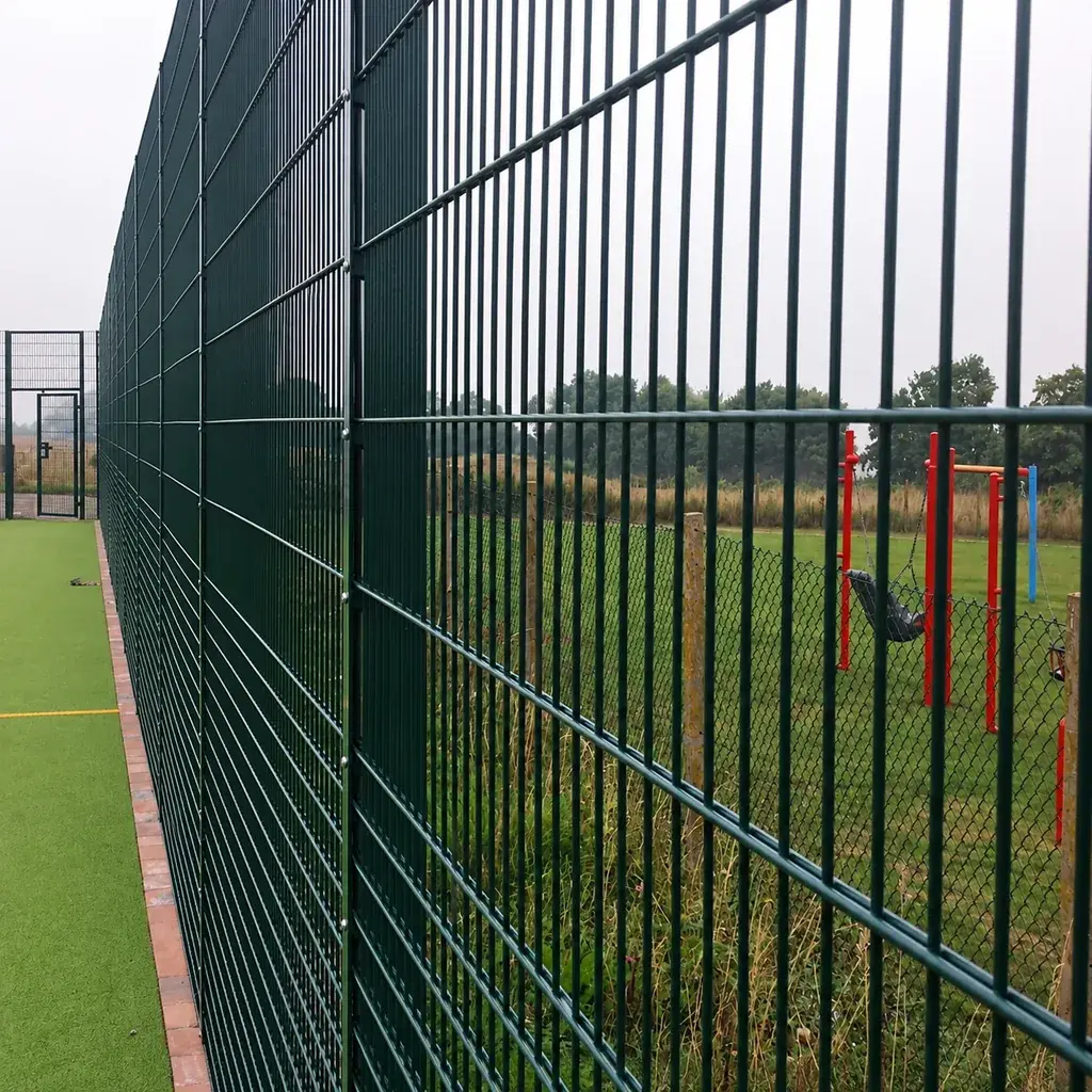 Rebound fence showing lower mesh zone beside the pitch