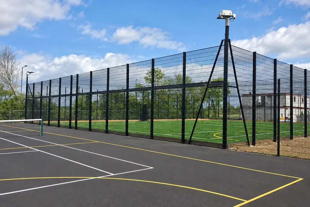 Tall mesh fencing around a marked school ball court