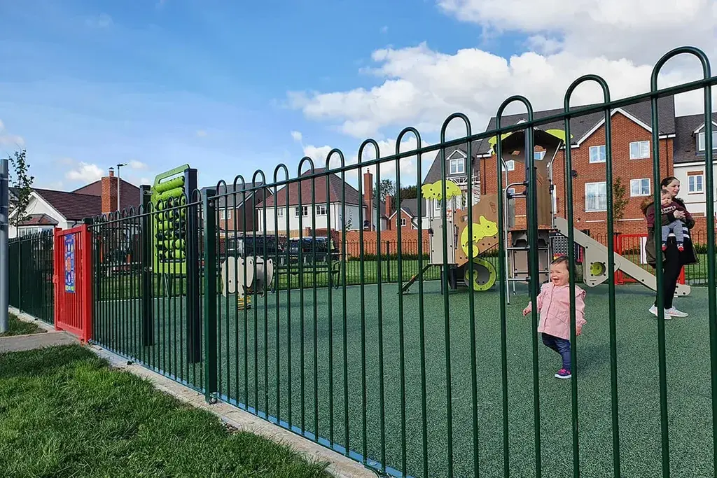 Green bow-top railing around a playground entrance