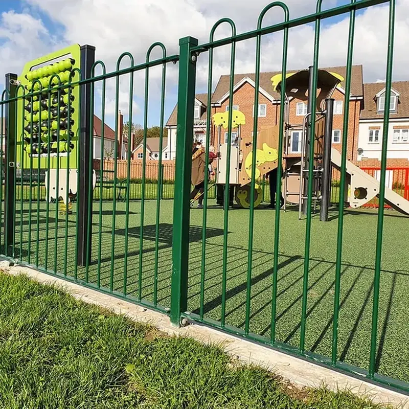 Green bow-top playground gate within a matching fence line