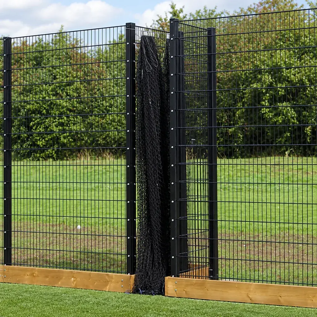 Retracted sports divider net gathered between two mesh fence posts