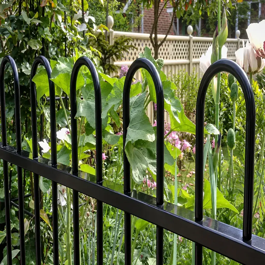 Black bow-top railings beside garden plants