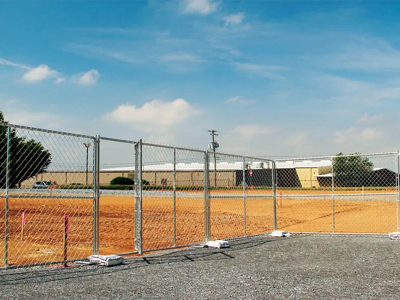 Temporary chain link fence panels with freestanding feet beside a work site