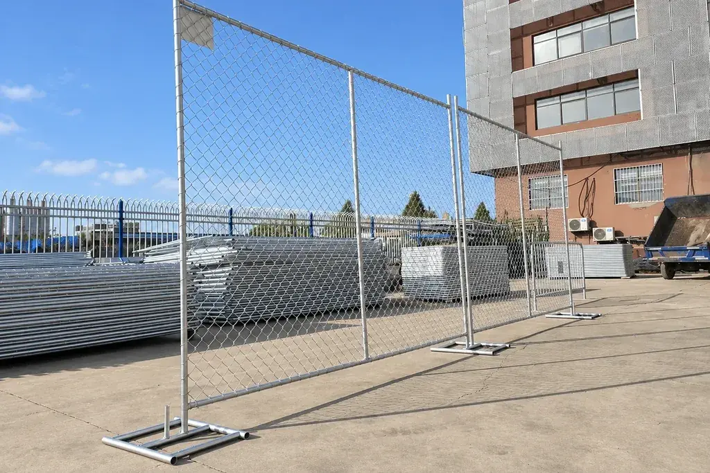 Freestanding temporary chain link panels on rectangular metal feet in a yard