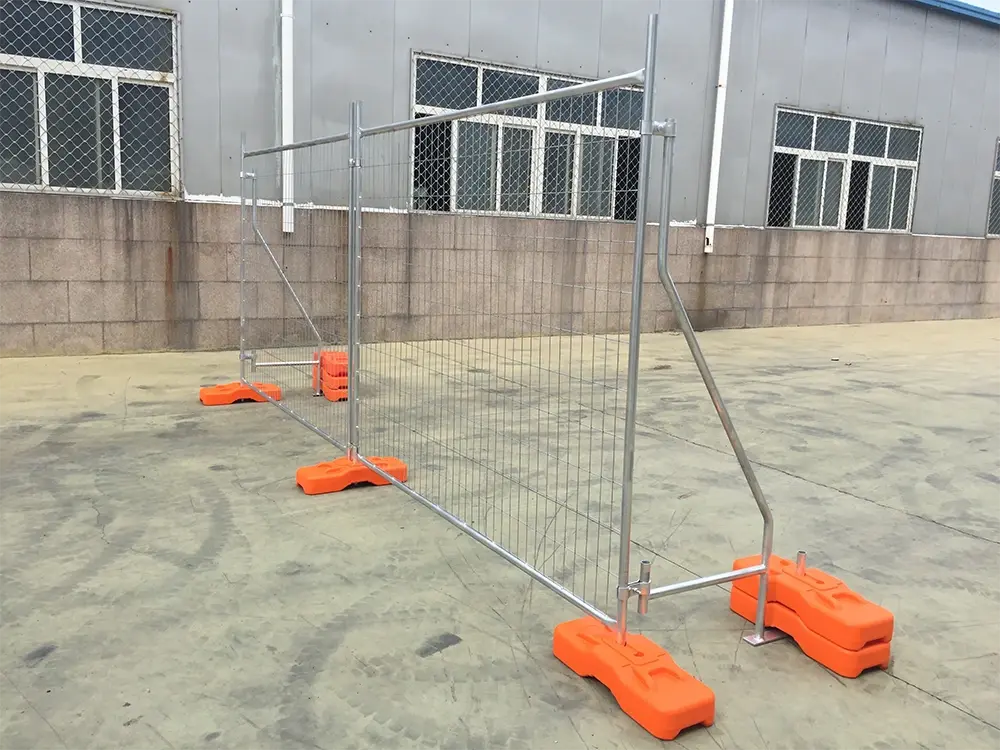 Temporary welded mesh fence legs seated in orange weighted bases