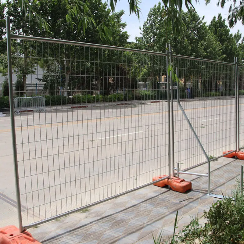 Temporary welded mesh panel supported by orange weighted bases